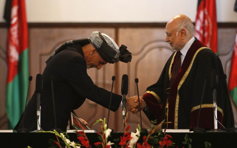 Afghanistan's new President Ashraf Ghani Ahmadzai shake hands with Afghanistan's Chief Justice Abdul Salam Azimi as he takes the oath during his inauguration as president in Kabul